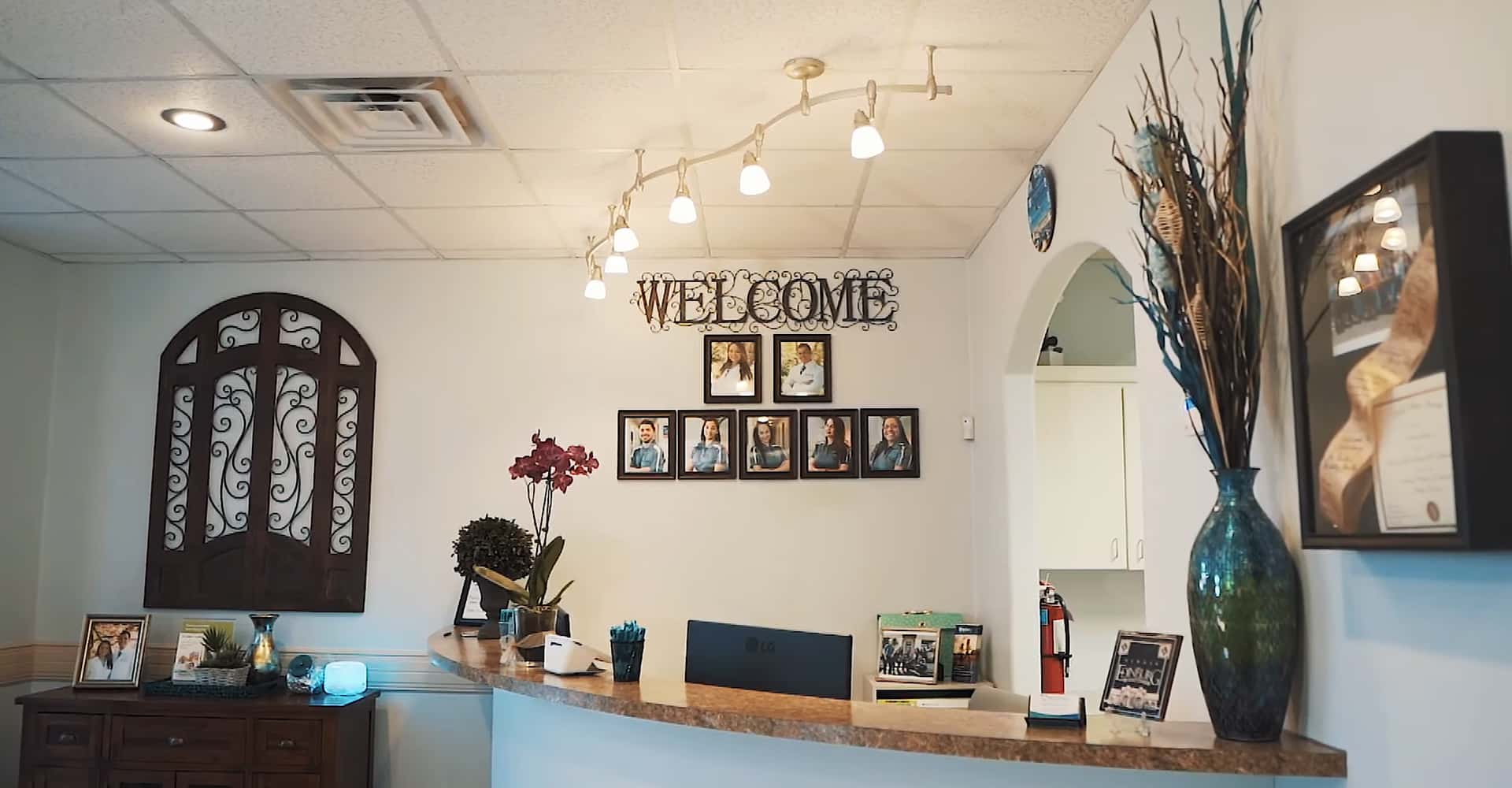 Welcoming dental office reception area with modern decor, welcome sign, and front desk.
